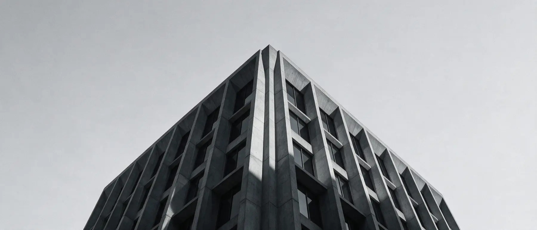 IT consultancy Sharjah - Low-angle view of a brutalist concrete tower against an overcast sky