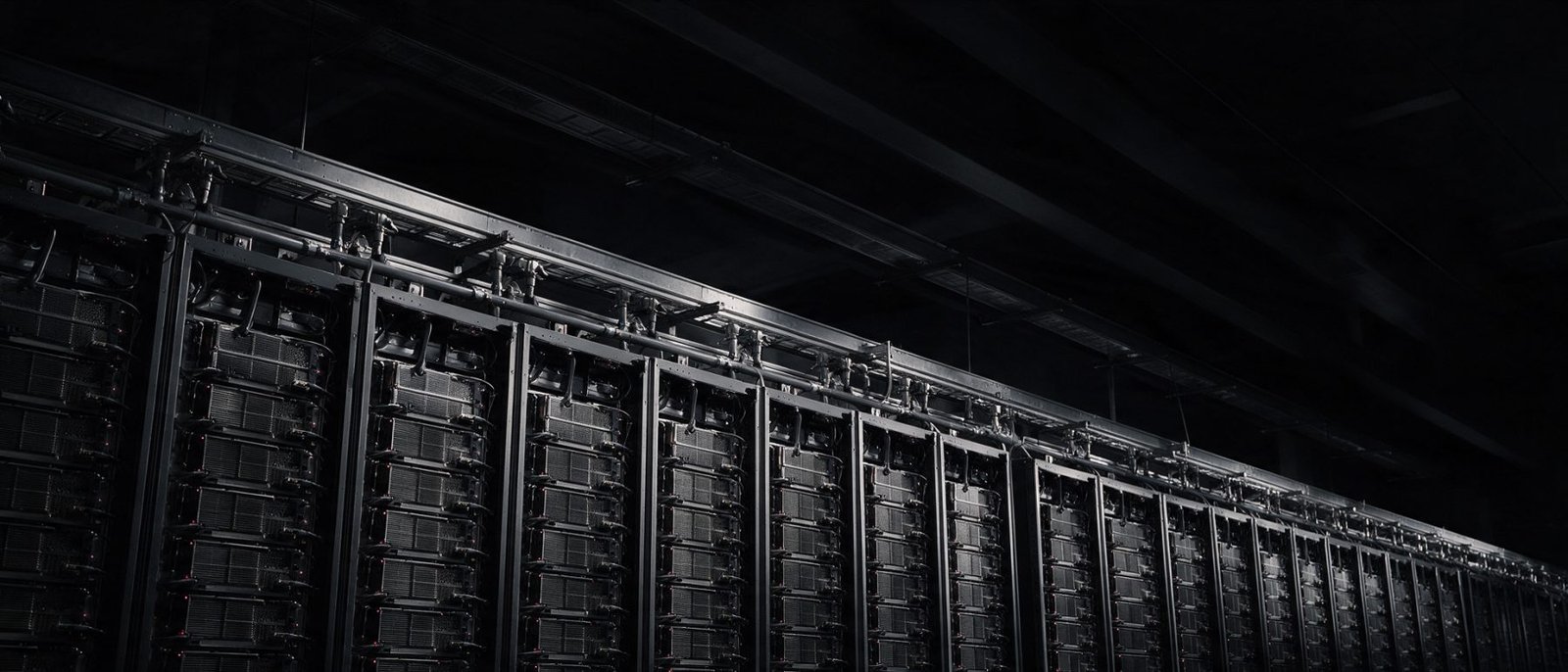 Business automation UAE - Low-angle view down a row of high-density GPU compute racks with power busway and cooling manifolds overhead