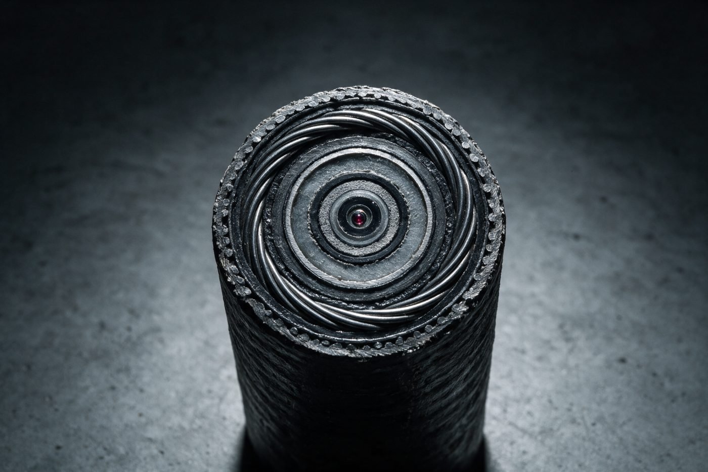 Cut cross-section of a heavy armoured submarine fibre optic cable showing concentric steel armour layers